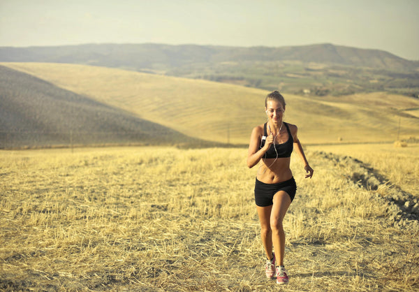 Woman running outdoors on a sunny hillside